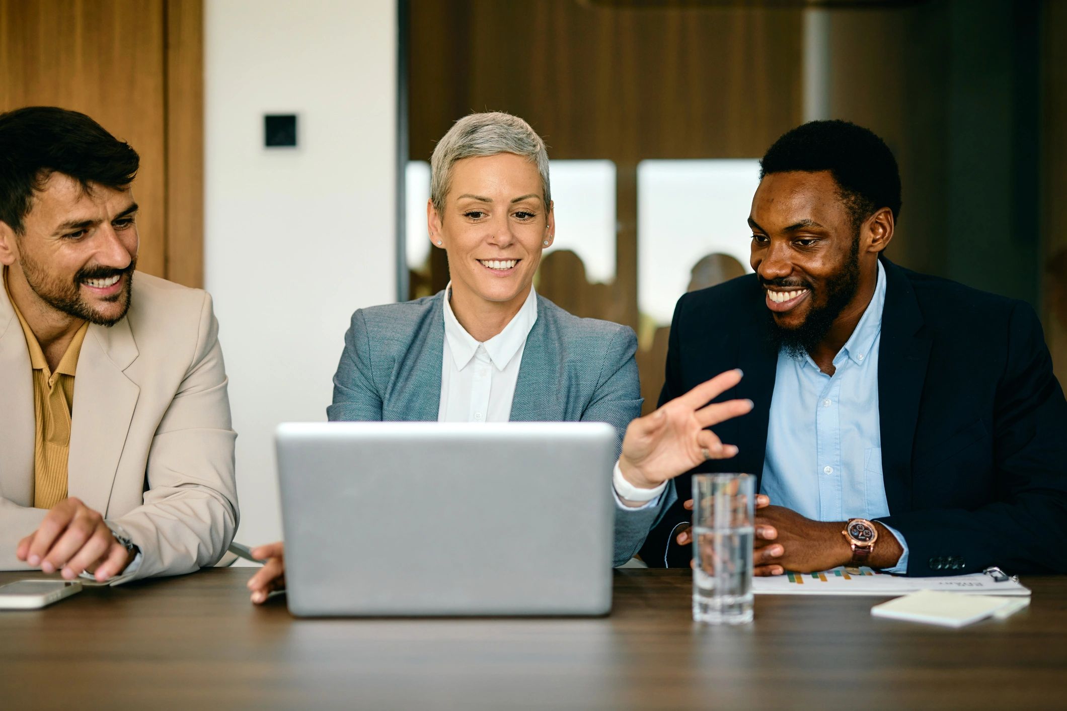 Real estate professionals collaborating around a laptop